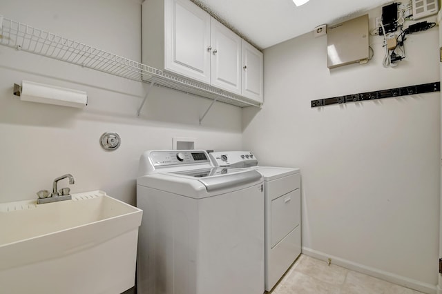 clothes washing area featuring cabinets, sink, light tile patterned floors, and washer and clothes dryer