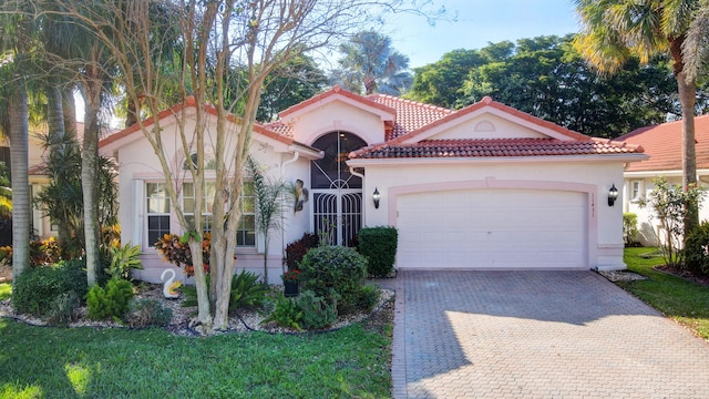 mediterranean / spanish house with a garage and a front lawn