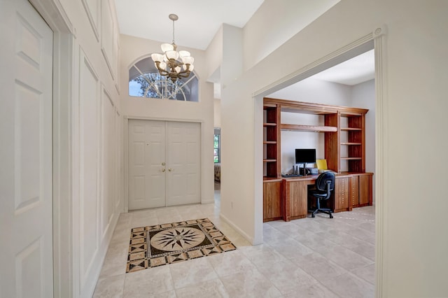 foyer featuring a towering ceiling and a chandelier