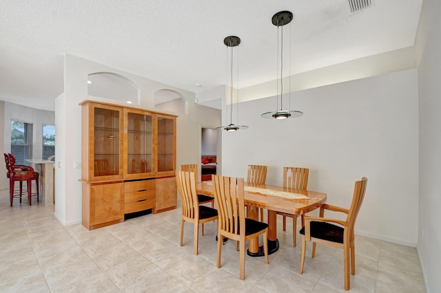 dining area with light tile patterned floors and a textured ceiling