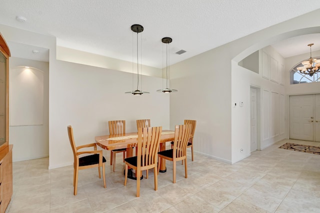 dining room with a notable chandelier and a textured ceiling