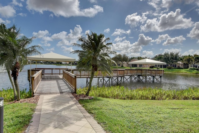 view of dock featuring a gazebo, a water view, and a yard