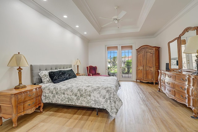 bedroom featuring a ceiling fan, light wood-style floors, access to outside, a tray ceiling, and crown molding