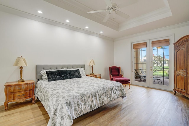 bedroom featuring a raised ceiling, ornamental molding, access to outside, french doors, and light wood-style floors