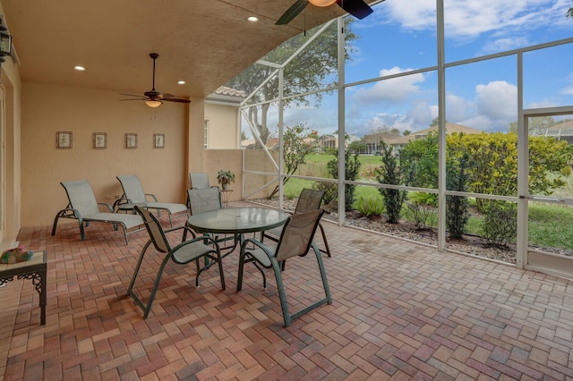 sunroom / solarium with a ceiling fan