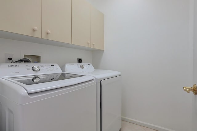 clothes washing area featuring cabinet space, independent washer and dryer, and baseboards