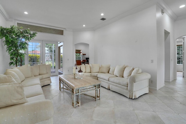 living area featuring plenty of natural light, arched walkways, crown molding, and recessed lighting