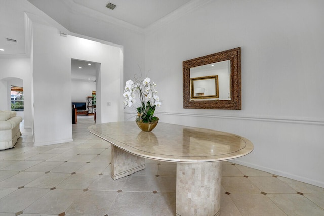 unfurnished dining area with arched walkways, crown molding, and baseboards