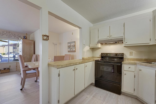 kitchen with white cabinets, light hardwood / wood-style floors, kitchen peninsula, black range with electric stovetop, and a textured ceiling