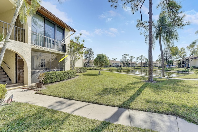 view of property's community featuring a water view and a lawn