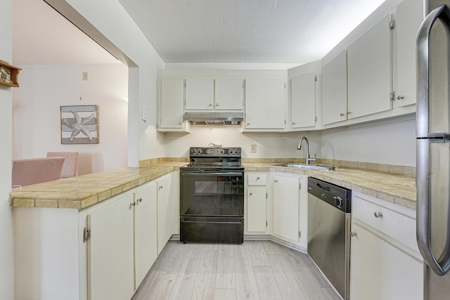 kitchen featuring sink, kitchen peninsula, white cabinets, and appliances with stainless steel finishes