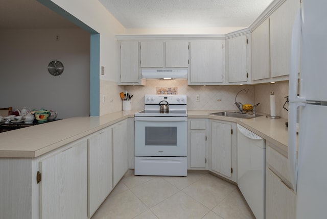 kitchen featuring sink, light tile patterned floors, white appliances, a textured ceiling, and kitchen peninsula