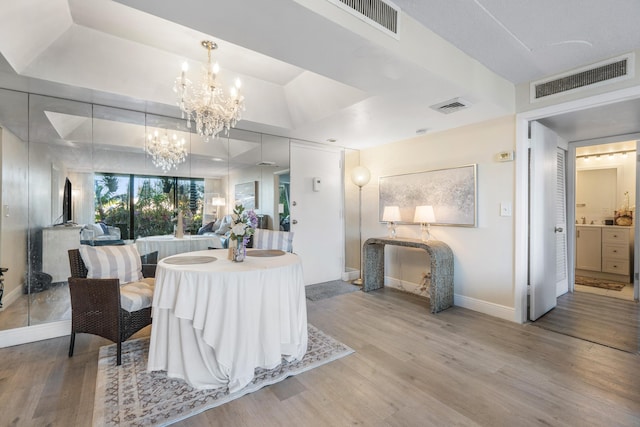 dining area with wood-type flooring and a chandelier