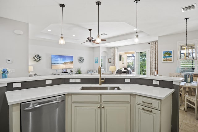 kitchen featuring a raised ceiling, plenty of natural light, sink, and stainless steel dishwasher