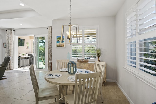 tiled dining room featuring a chandelier