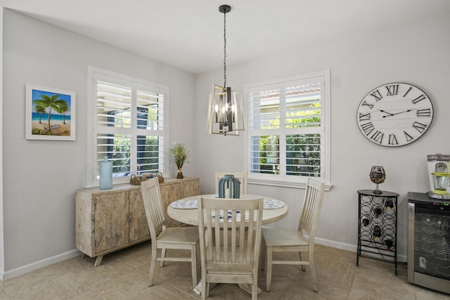 dining space featuring wine cooler and a notable chandelier