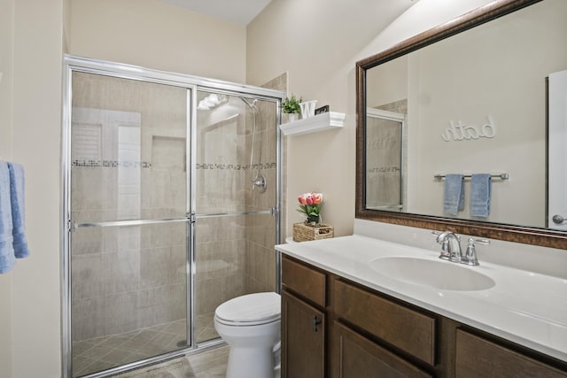 bathroom featuring vanity, walk in shower, and toilet