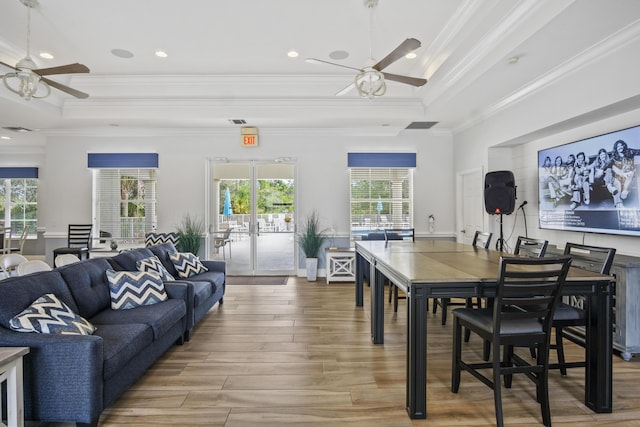 dining room featuring a raised ceiling, hardwood / wood-style floors, and ceiling fan