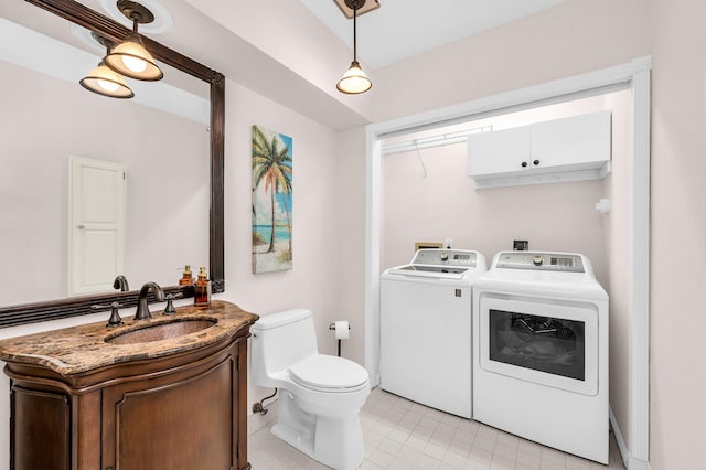 bathroom with vanity, washer and dryer, and toilet