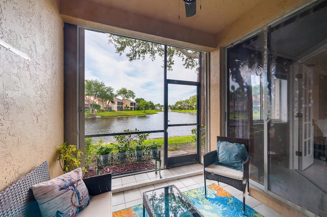 sunroom / solarium with a water view and ceiling fan