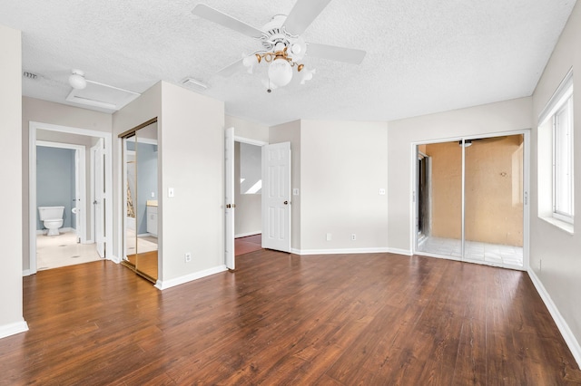 unfurnished bedroom featuring dark hardwood / wood-style flooring, a textured ceiling, ensuite bath, and ceiling fan