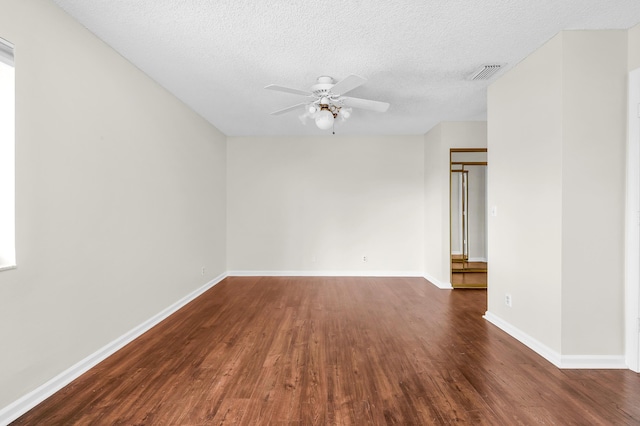 spare room featuring dark wood-type flooring, ceiling fan, and a textured ceiling