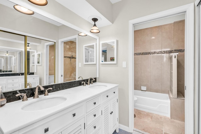 full bathroom featuring vanity, tiled shower / bath, and toilet