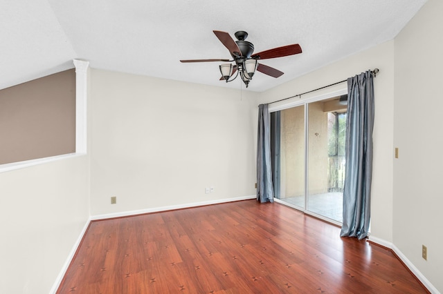 unfurnished room featuring ornate columns, ceiling fan, wood-type flooring, and lofted ceiling