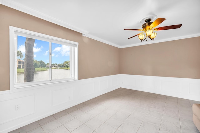 tiled empty room with crown molding, a water view, and ceiling fan