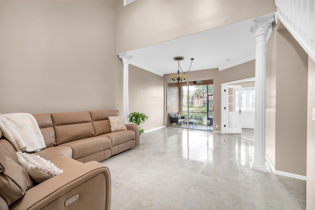 living room featuring an inviting chandelier, ornamental molding, and ornate columns