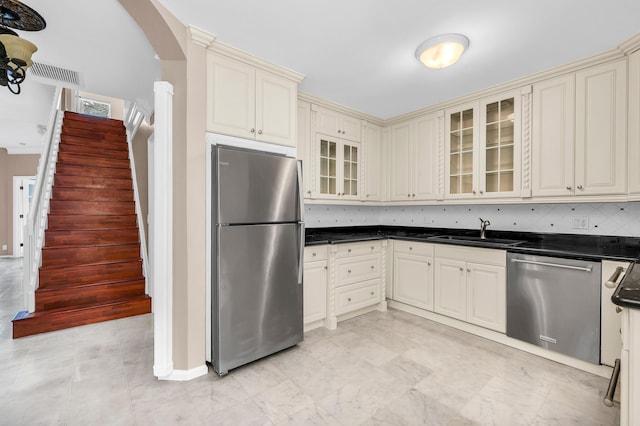 kitchen featuring cream cabinets, backsplash, sink, and appliances with stainless steel finishes