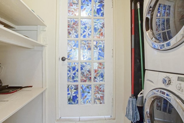 clothes washing area with stacked washing maching and dryer