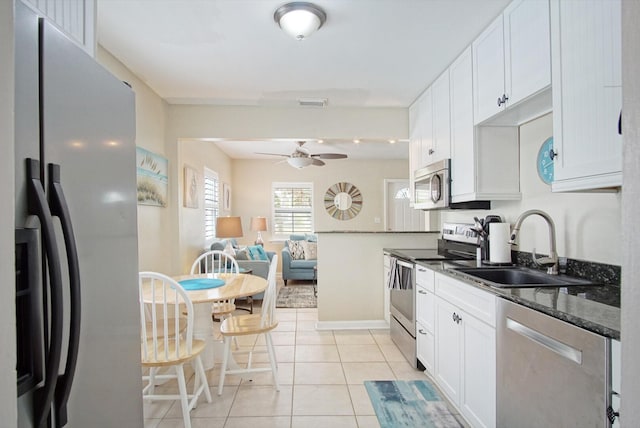 kitchen with sink, light tile patterned floors, white cabinets, and appliances with stainless steel finishes