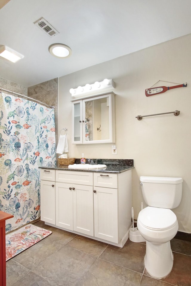 bathroom featuring vanity, tile patterned floors, toilet, and walk in shower