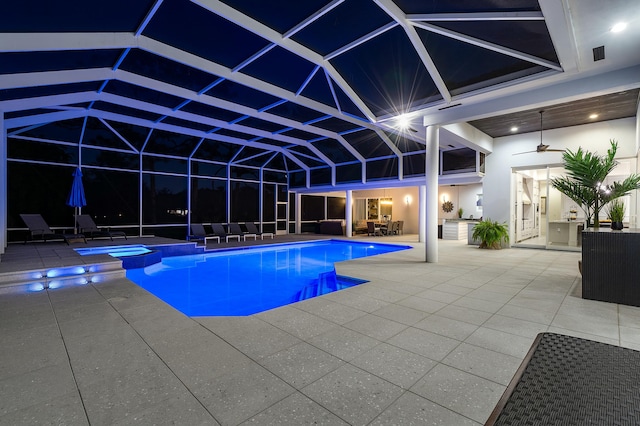 view of swimming pool with ceiling fan, glass enclosure, and a patio area