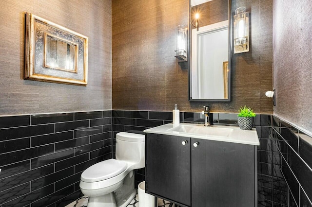 bathroom with vanity, tile walls, and toilet