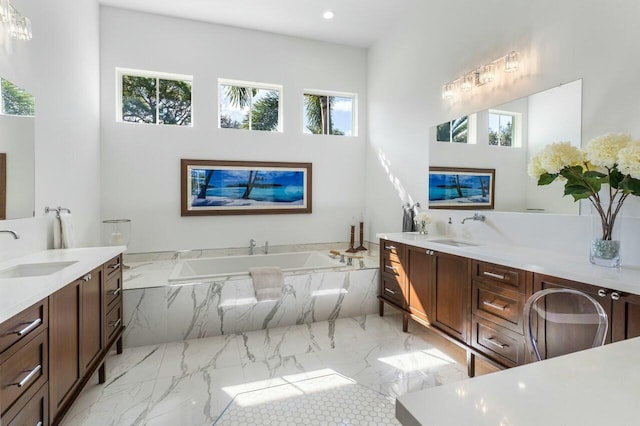 bathroom featuring vanity and tiled tub