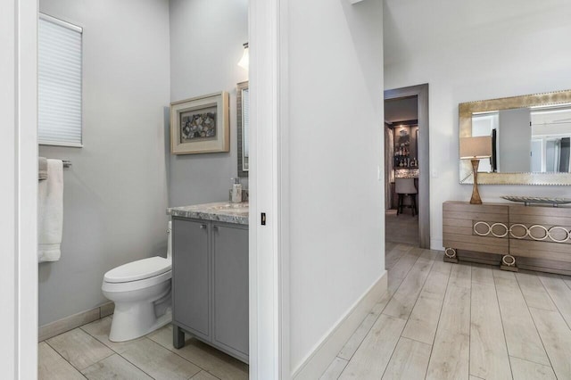 bathroom featuring vanity, wood-type flooring, and toilet