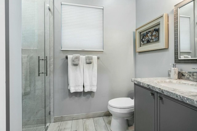 bathroom featuring walk in shower, vanity, toilet, and hardwood / wood-style flooring