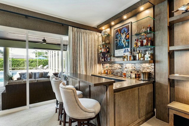 bar featuring ceiling fan and light carpet