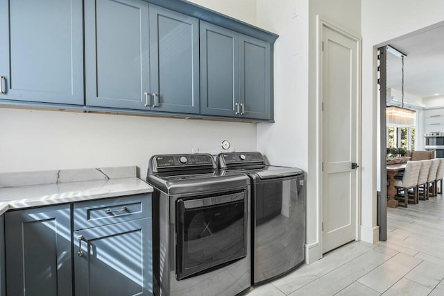 laundry room with cabinets and washing machine and clothes dryer