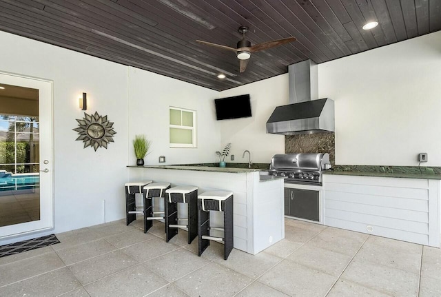 kitchen featuring light tile patterned floors, wood ceiling, white cabinetry, kitchen peninsula, and wall chimney exhaust hood