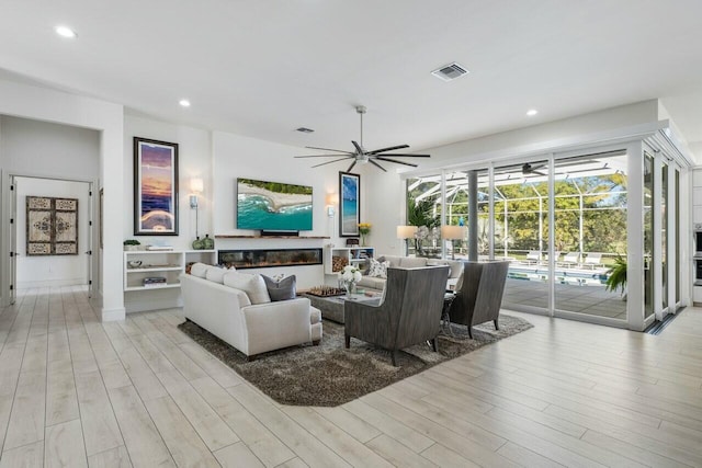 living room featuring ceiling fan and light wood-type flooring