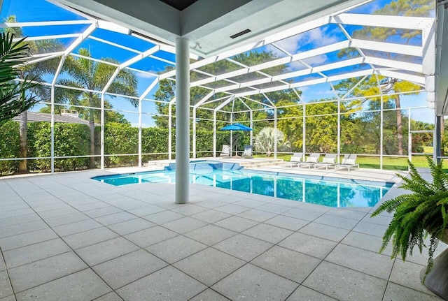 view of swimming pool featuring a patio and glass enclosure