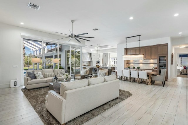 living room featuring ceiling fan and light wood-type flooring