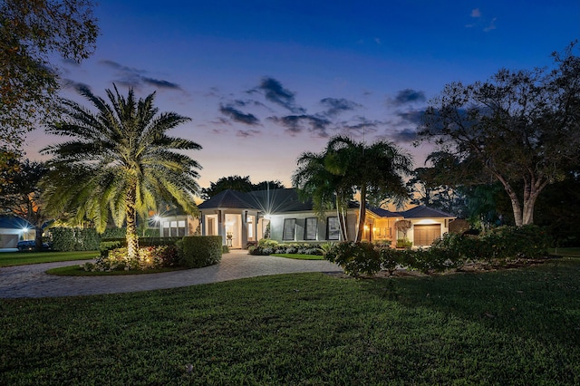 single story home featuring a yard and a garage