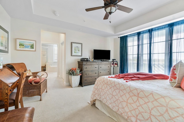 bedroom with multiple windows, light carpet, connected bathroom, and ceiling fan