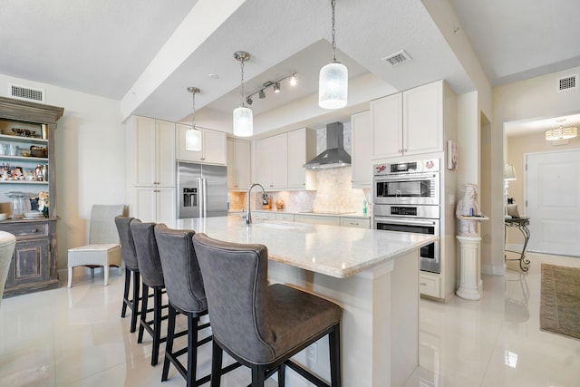 kitchen featuring white cabinetry, sink, backsplash, stainless steel appliances, and wall chimney exhaust hood