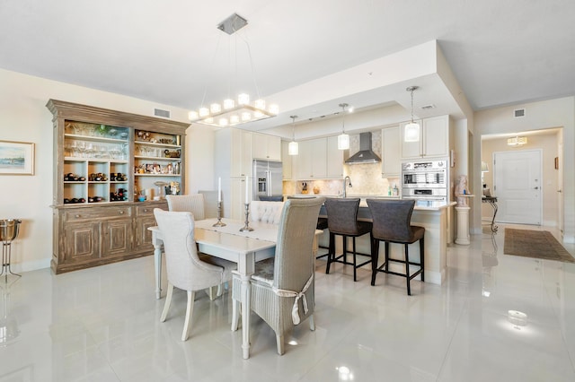 tiled dining room with a chandelier