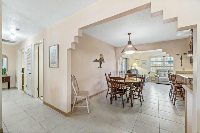 dining room with light tile patterned flooring and a textured ceiling